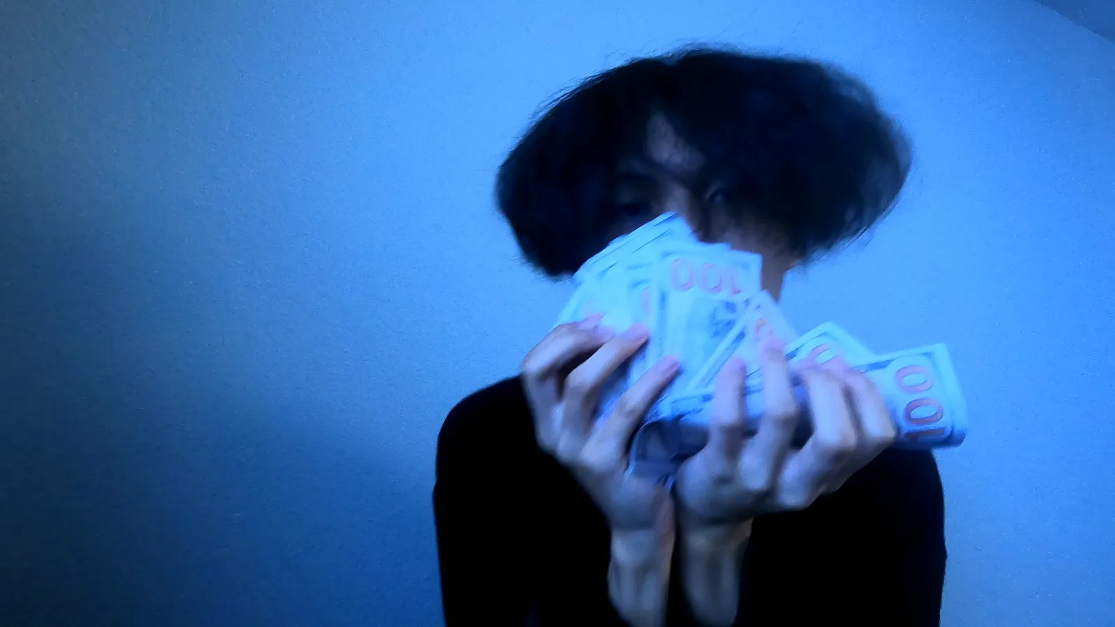 cavyion holding cash in front of his face